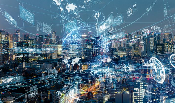 夜のビル群にデジタル情報が飛び交う光が広がる風景。情報過多の時代を象徴するイメージ。